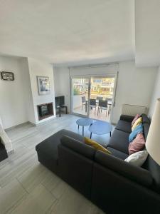 a living room with a couch and a table at Maison Empuriabrava proche canaux et Plage in Empuriabrava