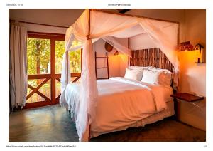 a bedroom with a bed with a canopy at Paka Bangalos, Pousada de Charme em Sergipe in Pacatuba