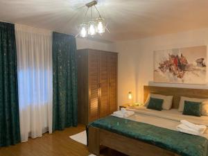 1 dormitorio con 1 cama grande y cortinas verdes en Aminah House, en Constanţa