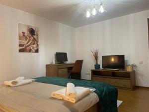 Un dormitorio con una cama y un escritorio con televisión. en Aminah House, en Constanţa