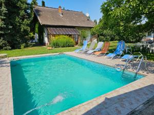 ein Swimmingpool mit Stühlen und ein Haus in der Unterkunft Haus Veronika in Zamárdi