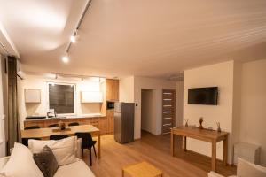 a living room and kitchen with a couch and a table at Domek Letniskowy 4E nad jeziorem nyskim in Skorochow