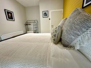 a bedroom with a bed with white sheets and pillows at Dream Catcher One bedroom apartment in Downpatrick +5 photos