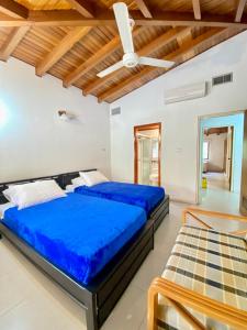 a bedroom with two beds and a ceiling fan at Exclusiva Villa con Salida al Mar in Santa Marta