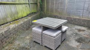 ロンドンにあるGarland Spacious 4 Bedroom House With Garden And Parkingのレンガの壁の横に置かれたピクニックテーブルと椅子2脚