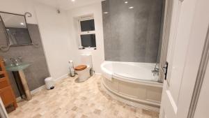 ロンドンにあるGarland Spacious 4 Bedroom House With Garden And Parkingの浴槽、トイレ、洗面台を備えたバスルーム +54枚の写真