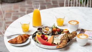 a tray of breakfast food on a table with orange juice at Hotel Brummell in Barcelona