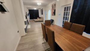 ロンドンにあるGarland Spacious 4 Bedroom House With Garden And Parkingの木製のテーブルと椅子のあるダイニングルーム