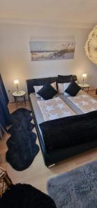 a large bed in a room with two tables at Stadtrand Haushälfte in Wilhelmshaven