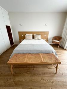 a bedroom with a large bed with a wooden headboard at Refúgio Verde Douro in Marco de Canaveses