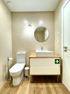 a bathroom with a toilet and a sink and a mirror at Refúgio Verde Douro in Marco de Canaveses +16 photos