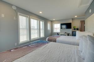 a bedroom with two beds and windows and a tv at Ocean Lodge Hotel North in Ocean City