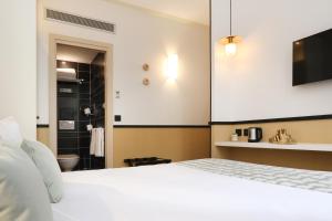 a bedroom with a white bed and a bathroom at Five Boutique Hotel Paris Quartier Latin in Paris