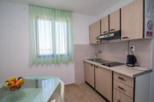 a kitchen with a glass table and a bowl of fruit at Castello in Mali Lošinj