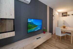 a living room with a television on a wall at Castello in Mali Lošinj