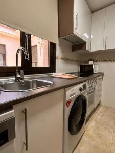 a kitchen with a sink and a washing machine at Casita El Gorrión in Sotillo de la Adrada