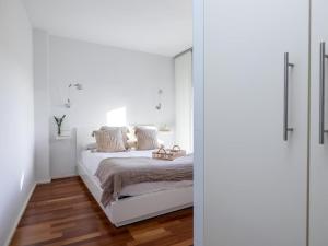 a bedroom with white walls and a bed with a mirror at Lovely House in Granada's Eye in Granada