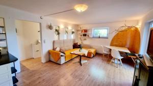 a living room with a couch and a table at Ruheoase am Waldrand - auf 90qm sind nicht nur die Eltern und bis zu 5 Kinder willkommen, auch Hunde und Katzen sind willkommen in Laichingen