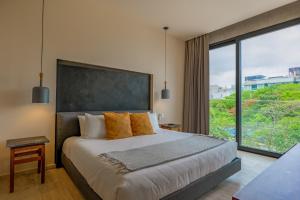 プラヤ・デル・カルメンにあるCeren 203の大きなベッドと大きな窓のある寝室 +28枚の写真