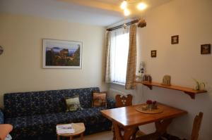 a living room with a couch and a table at Ferieneinrichtungen-Haus-am-Stein-Haus-2-Saechsische-Schweiz-Koenigstein in Königstein an der Elbe