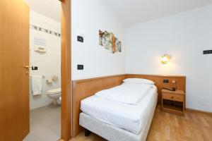 niewielka sypialnia z łóżkiem i toaletą w obiekcie Hotel Denny w mieście Pinzolo