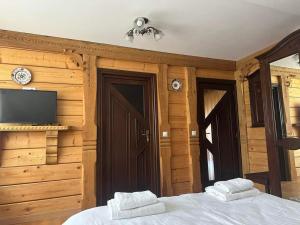 a bedroom with a bed and a flat screen tv at Casa Meșterului in Bîrsana