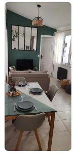 a living room with a table and a couch at Maisonnette cosy et calme in Mions