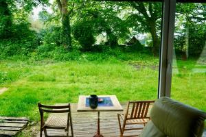 a table and chairs on a porch with a view of a yard at Charmantes Maisonette-Appartment in Cologne