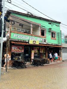 a building with people standing outside of a restaurant at Pousada Vida Mansa in Porto De Galinhas +13 photos