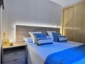a bedroom with a large bed with blue pillows at Casita El Gorrión in Sotillo de la Adrada +6 photos