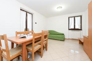 a dining room with a wooden table and chairs at Hotel Denny in Pinzolo