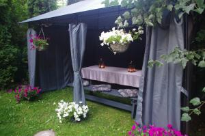 a black tent with a table and flowers in it at Private house 2km from old town in Riga