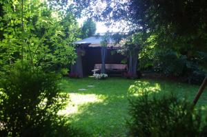 a gazebo with a bench in a yard at Private house 2km from old town in Riga +48 photos