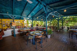 a restaurant with tables and chairs and a guitar at Social Camping JAL in Jal