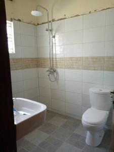 a bathroom with a toilet and a bath tub at Three bedroom house for stay in seeta town mukono in Seeta +4 photos