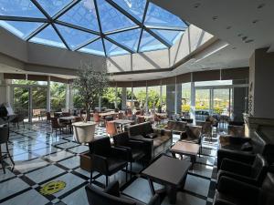 a restaurant with tables and chairs and a large glass ceiling at AAR Hotel & Spa in Ioannina