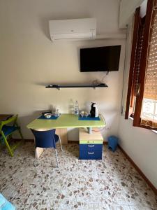 a green desk in a room with a chair and a tv at Via Roma House in Terralba