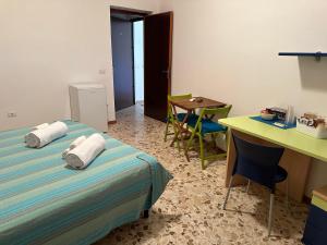 a room with a bed and a table and a desk at Via Roma House in Terralba