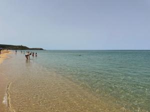 a group of people walking on the beach at Via Roma House in Terralba