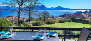a table with plates and wine glasses on a balcony at Pineta Tre Isole in Baveno