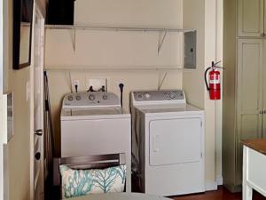 een keuken met 2 fornuizen en een wasmachine en droger bij CB Sunshine Cottage in Carolina Beach