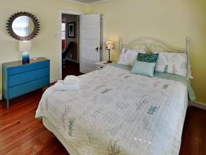 een slaapkamer met een groot bed en een blauw dressoir bij CB Sunshine Cottage in Carolina Beach