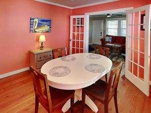 een eetkamer met een witte tafel en stoelen bij CB Sunshine Cottage in Carolina Beach