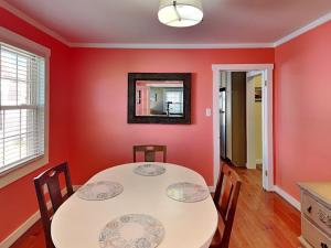 een eetkamer met rode muren en een tafel en stoelen bij CB Sunshine Cottage in Carolina Beach