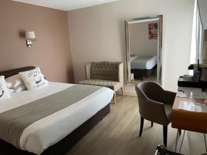 a hotel room with a bed and a mirror at Cit'Hotel Logis Le Chêne Vert in Les Sables-d'Olonne