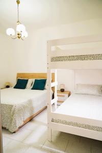 a bedroom with two bunk beds and a chandelier at Casetta Dolce Mare - FELICITA' a DUE PASSI dal MARE in Villanova di Ostuni