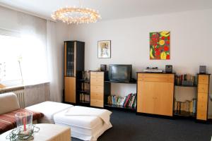 a living room with a couch and a tv and book shelves at Ferienwohnung Rheda-Wiedenbrück in Rheda-Wiedenbrück