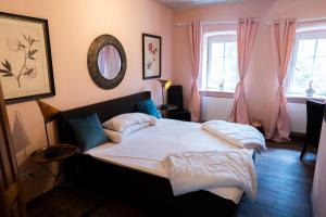 ein Schlafzimmer mit einem Bett mit weißen Laken und Kissen in der Unterkunft Hotel und Restaurant Halbinsel in Blieskastel