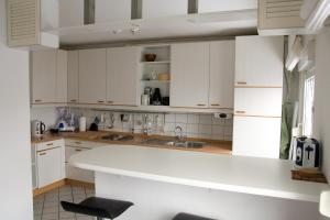 eine Küche mit weißen Schränken und einer weißen Arbeitsplatte in der Unterkunft Ferienwohnung Rheda-Wiedenbrück in Rheda-Wiedenbrück