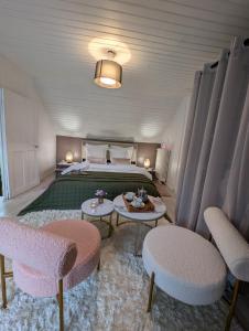 a bedroom with a bed and two tables and chairs at La Petite Maison de Locarn in Locarn